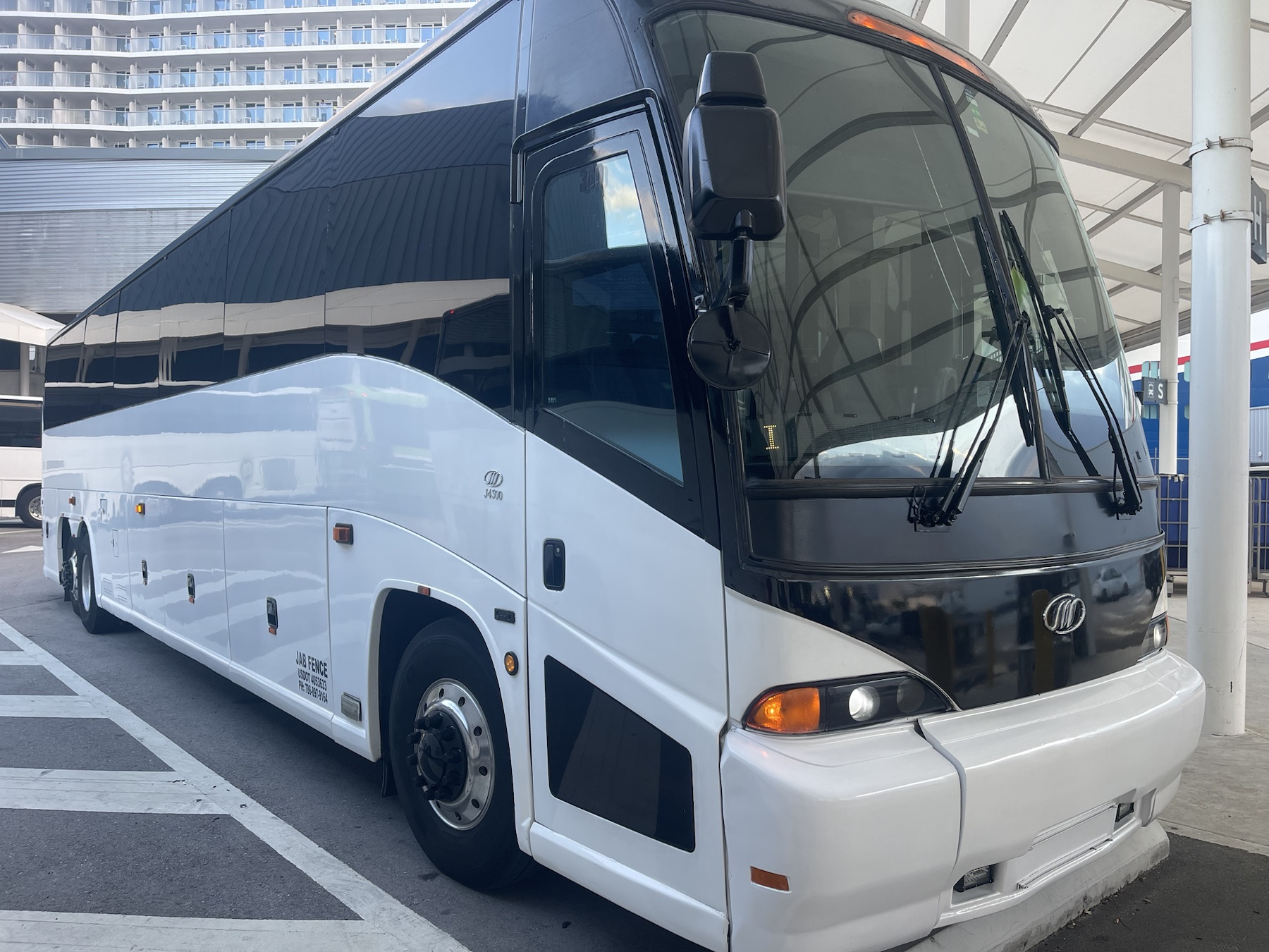 Angled exterior view of a white and black coach bus ready for charter service